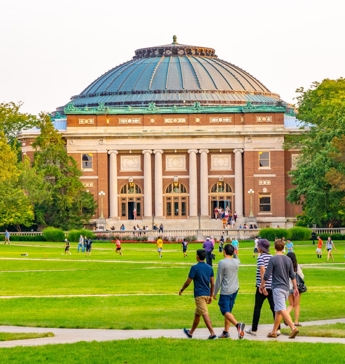 Students walking on walkway to class with dorm in the background
